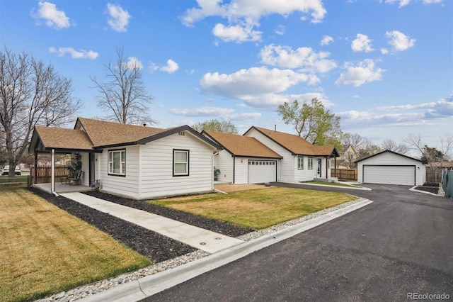 ranch-style house with a front lawn, a shingled roof, an outdoor structure, and a garage