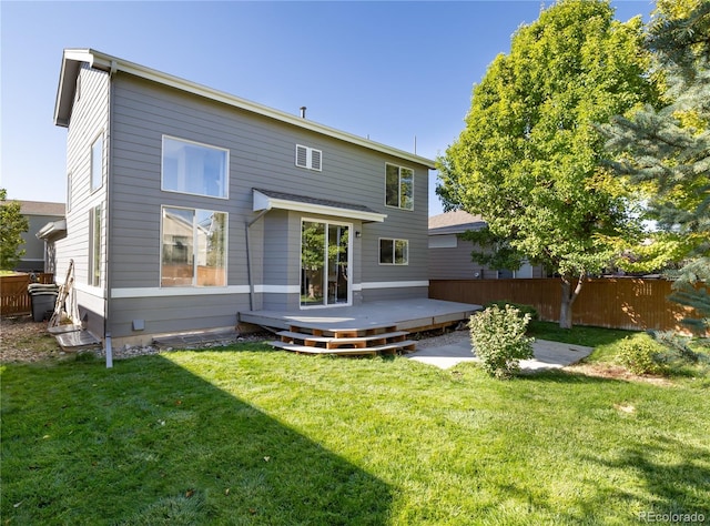 rear view of house with a wooden deck and a lawn