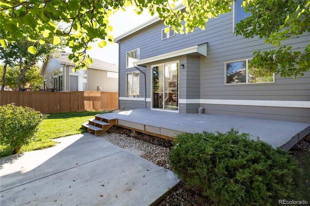 rear view of house featuring a yard and a deck