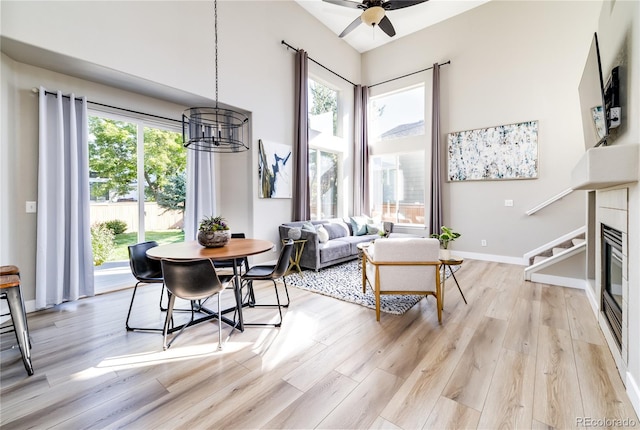 dining area with ceiling fan with notable chandelier and light hardwood / wood-style floors