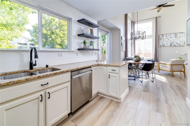 kitchen with light wood-type flooring, plenty of natural light, sink, and stainless steel dishwasher