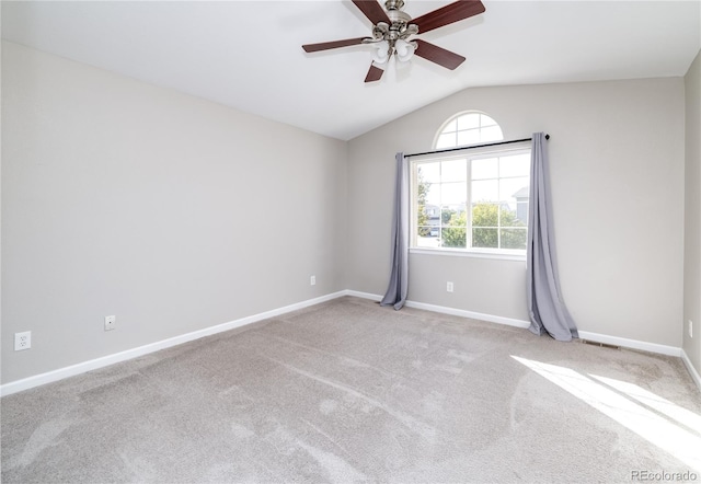 spare room with lofted ceiling, ceiling fan, and light colored carpet