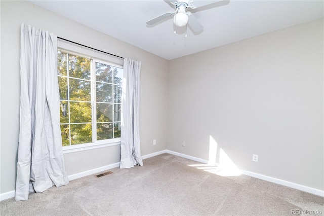 carpeted spare room featuring ceiling fan