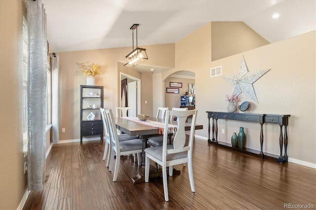 56330 E 37th Ct, Strasburg, CO 80136 - dining space featuring arched walkways, baseboards, lofted ceiling, dark wood-type flooring, and visible vents
