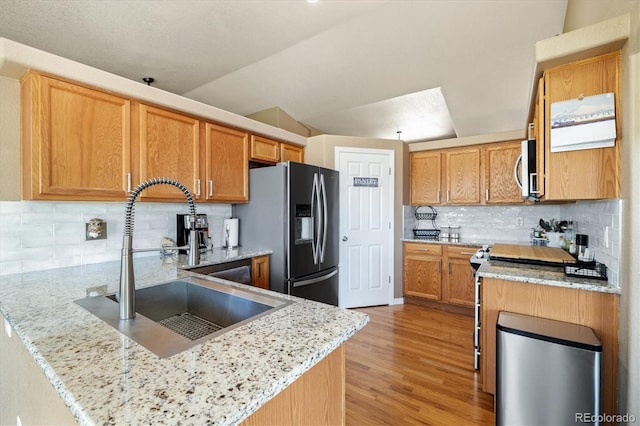 56330 E 37th Ct, Strasburg, CO 80136 - kitchen with stainless steel appliances, a peninsula, a sink, and light stone counters