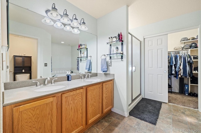 56330 E 37th Ct, Strasburg, CO 80136 - full bath featuring a walk in closet, double vanity, a stall shower, and a sink