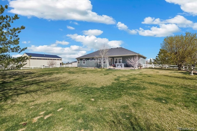 56330 E 37th Ct, Strasburg, CO 80136 - back of property featuring a lawn, a fenced backyard, and a patio area
