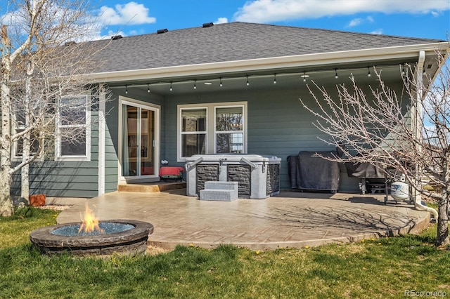 56330 E 37th Ct, Strasburg, CO 80136 - back of house with roof with shingles, stone siding, a patio, and an outdoor fire pit