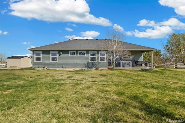 56330 E 37th Ct, Strasburg, CO 80136 - back of property featuring a storage unit, a patio area, an outbuilding, and a lawn