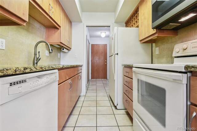 kitchen with decorative backsplash, a sink, white appliances, and light tile patterned floors