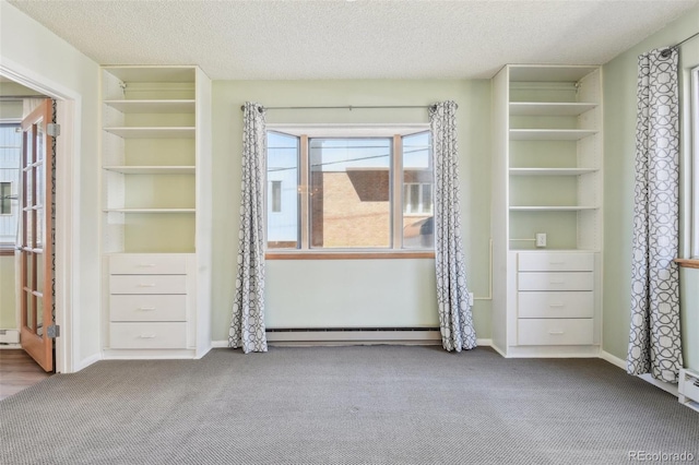 interior space featuring a textured ceiling, carpet flooring, and baseboard heating