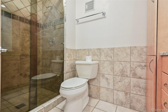 full bathroom with toilet, tile walls, visible vents, and a stall shower