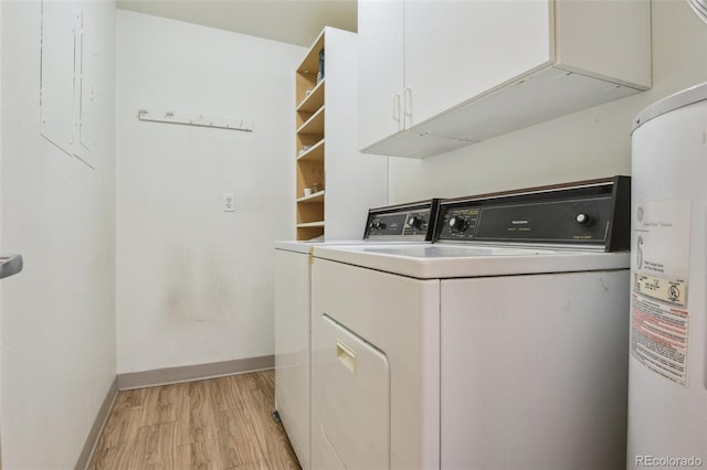 washroom featuring baseboards, water heater, cabinet space, and light wood-type flooring