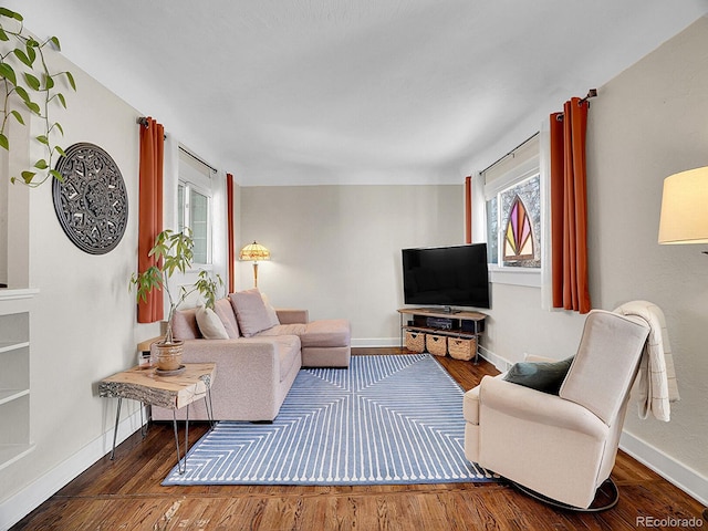 living room featuring a healthy amount of sunlight and dark wood-type flooring