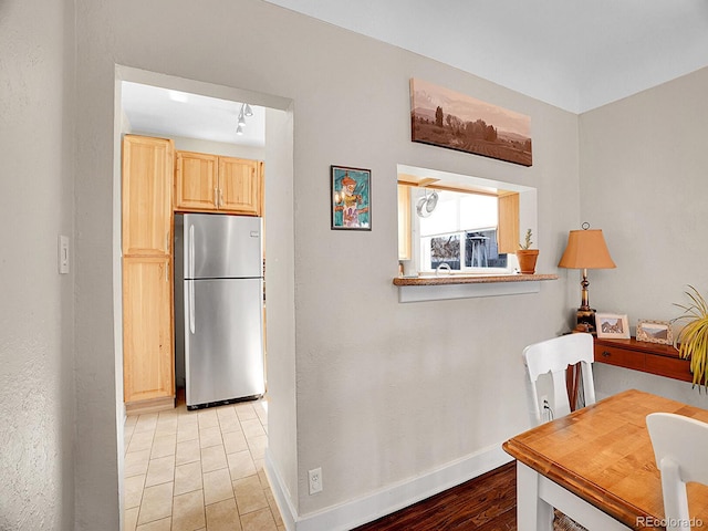 kitchen featuring light hardwood / wood-style flooring, stainless steel fridge, and light brown cabinets