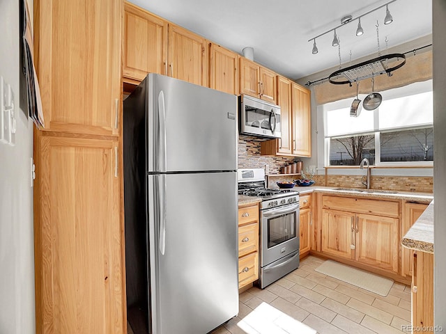 kitchen with backsplash, appliances with stainless steel finishes, sink, and light brown cabinets