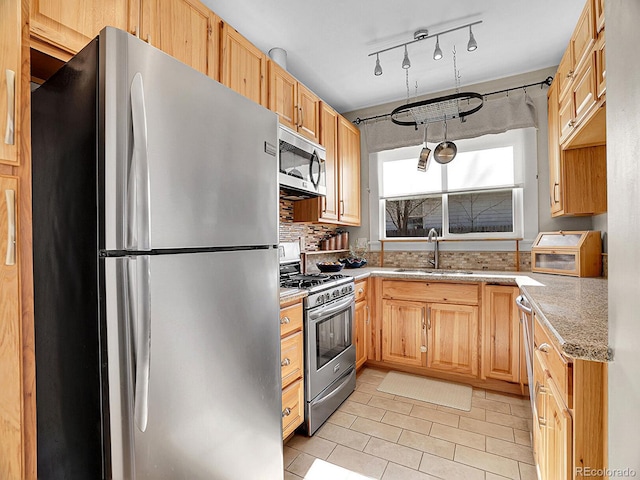 kitchen featuring sink, decorative backsplash, light tile patterned floors, stainless steel appliances, and light brown cabinets