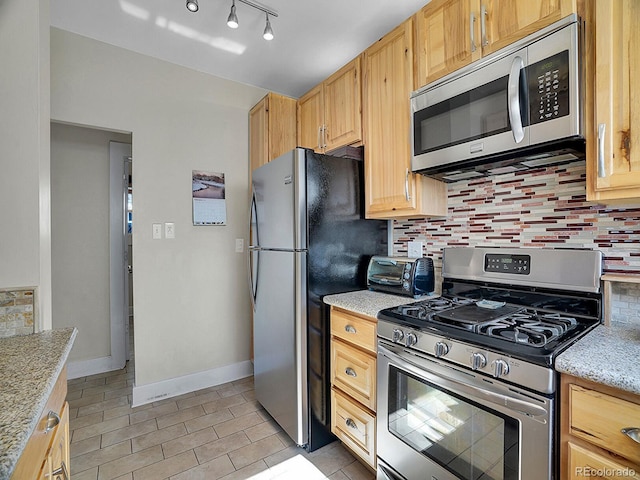 kitchen featuring stainless steel appliances, backsplash, and light brown cabinetry