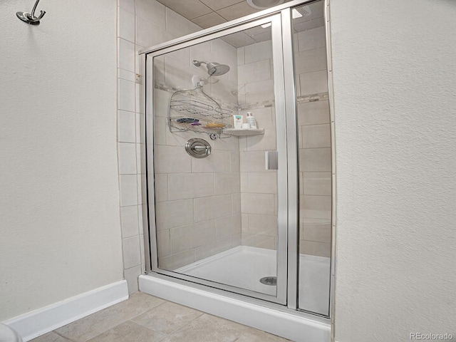 bathroom with tile patterned floors and a shower with shower door