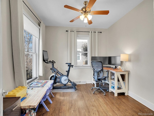 office with light hardwood / wood-style flooring and ceiling fan