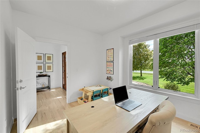 office space with light wood-type flooring and baseboards