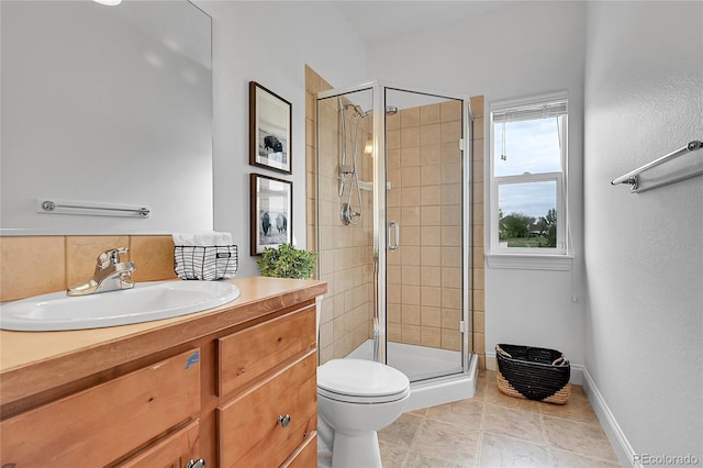 bathroom with a shower stall, toilet, baseboards, vanity, and tile patterned flooring
