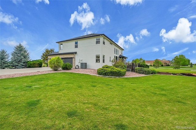 view of side of home featuring a yard, a garage, driveway, and central AC unit