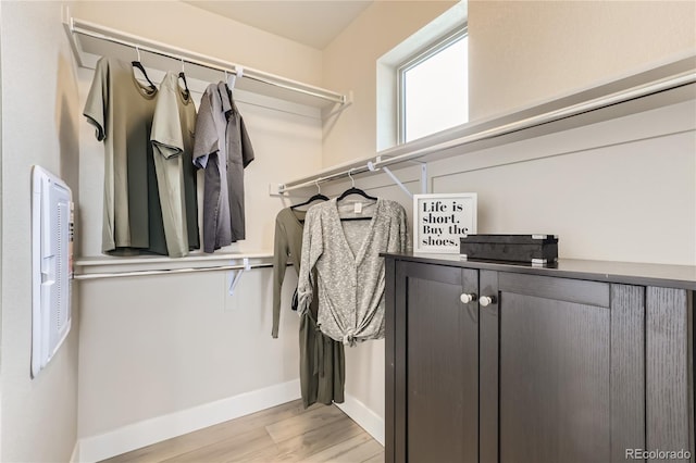 walk in closet with light hardwood / wood-style flooring