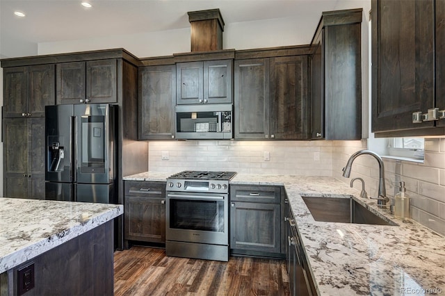 701 Saddle Ridge Cir, Granby, CO 80446 - kitchen with appliances with stainless steel finishes, light stone counters, a sink, dark brown cabinetry, and dark wood-style floors
