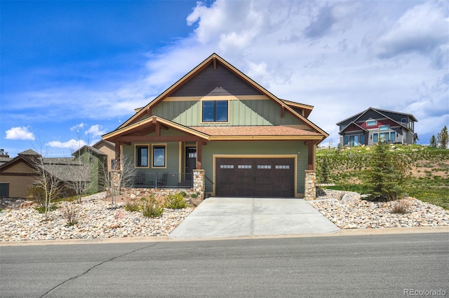 701 Saddle Ridge Cir, Granby, CO 80446 - craftsman-style house with a porch, driveway, board and batten siding, a garage, and stone siding