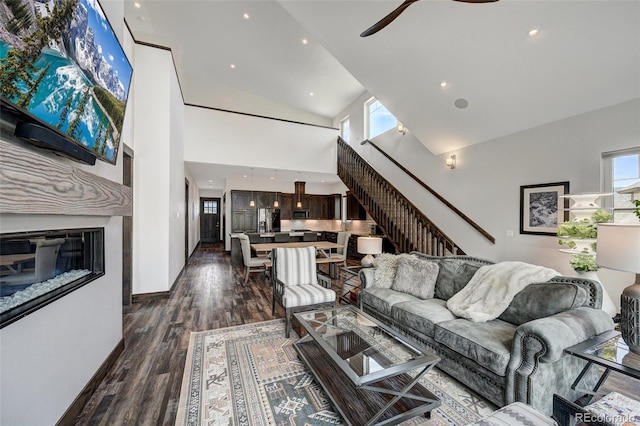 701 Saddle Ridge Cir, Granby, CO 80446 - living room with high vaulted ceiling, stairway, a ceiling fan, dark wood-style flooring, and baseboards