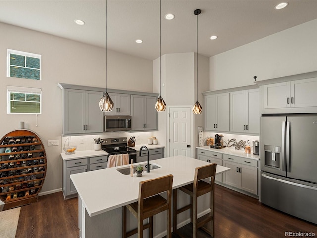 27110 E Fremont Pl, Aurora, CO 80016 - kitchen featuring stainless steel appliances, a sink, gray cabinets, backsplash, and a kitchen island with sink