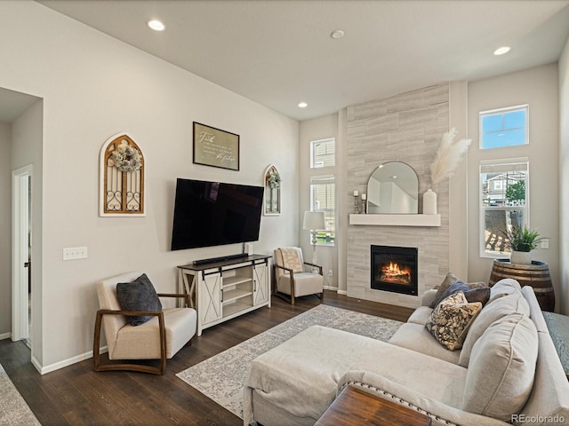 27110 E Fremont Pl, Aurora, CO 80016 - living area featuring healthy amount of natural light, a tiled fireplace, dark wood-type flooring, baseboards, and recessed lighting