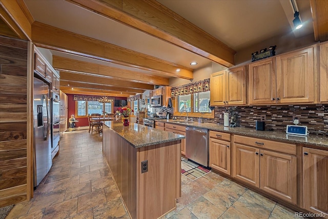 kitchen with appliances with stainless steel finishes, beam ceiling, light tile floors, and a wealth of natural light