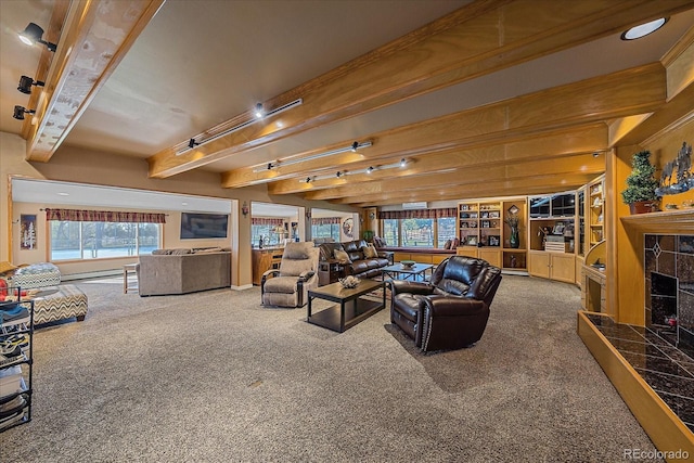 carpeted living room with beamed ceiling, baseboard heating, and a tiled fireplace