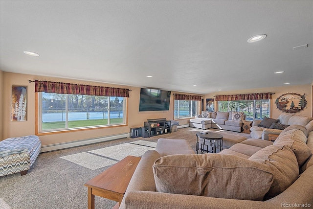 living room with a water view, a baseboard heating unit, and carpet floors