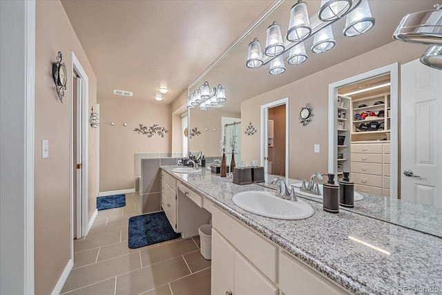 bathroom featuring tile floors, vanity with extensive cabinet space, and dual sinks