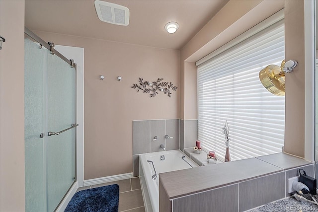 bathroom featuring tile flooring and independent shower and bath