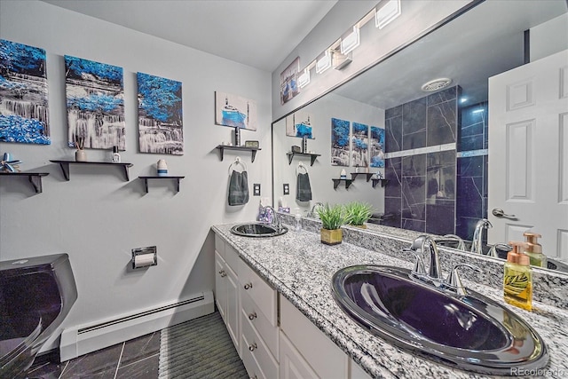 bathroom with large vanity, double sink, baseboard heating, and tile flooring