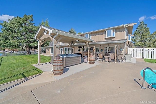 back of house featuring a patio, a swimming pool with hot tub, and a lawn