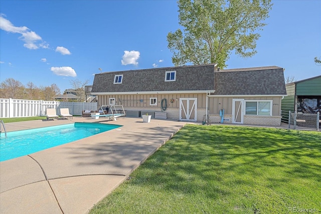 view of pool featuring a patio and a yard