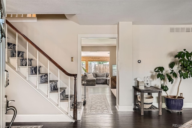6494 W 85th Ave, Arvada, CO 80003 - entryway featuring wood finished floors, a textured ceiling, and stairs