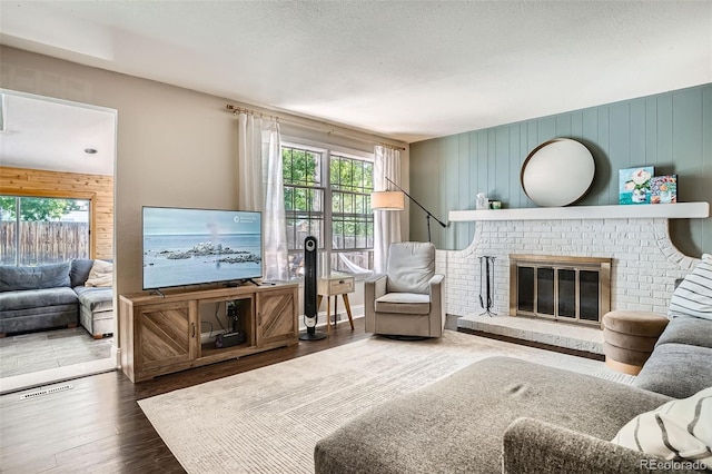 6494 W 85th Ave, Arvada, CO 80003 - living room with healthy amount of natural light, wood finished floors, a brick fireplace, and wood walls