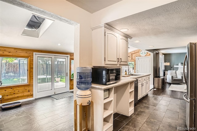 6494 W 85th Ave, Arvada, CO 80003 - kitchen featuring black microwave, freestanding refrigerator, wooden walls, light countertops, and open shelves
