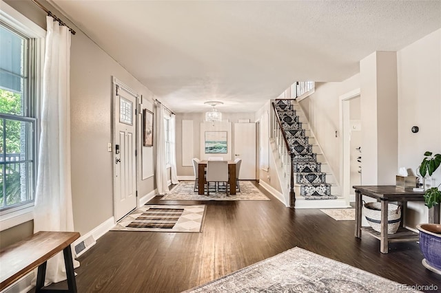 6494 W 85th Ave, Arvada, CO 80003 - entryway with wood finished floors, a chandelier, and stairway