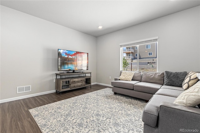 living room featuring dark wood-style floors, baseboards, and visible vents