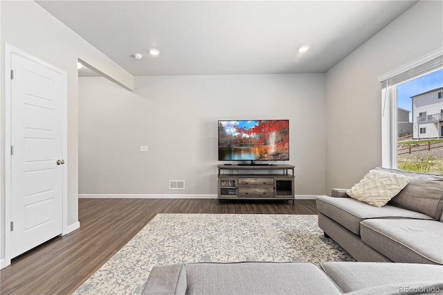 living area featuring baseboards, visible vents, and dark wood-type flooring