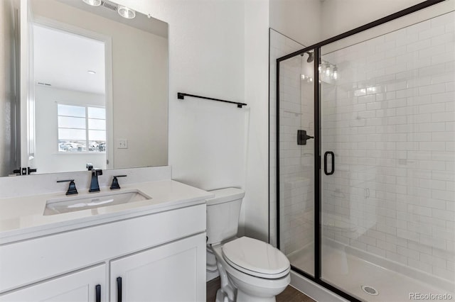 bathroom featuring vanity, toilet, and walk in shower