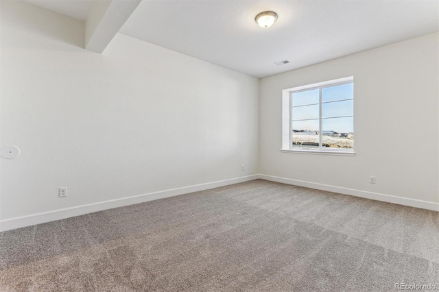 unfurnished room with beam ceiling and carpet flooring