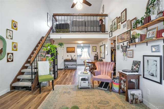 interior space featuring ceiling fan, hardwood / wood-style floors, and a high ceiling